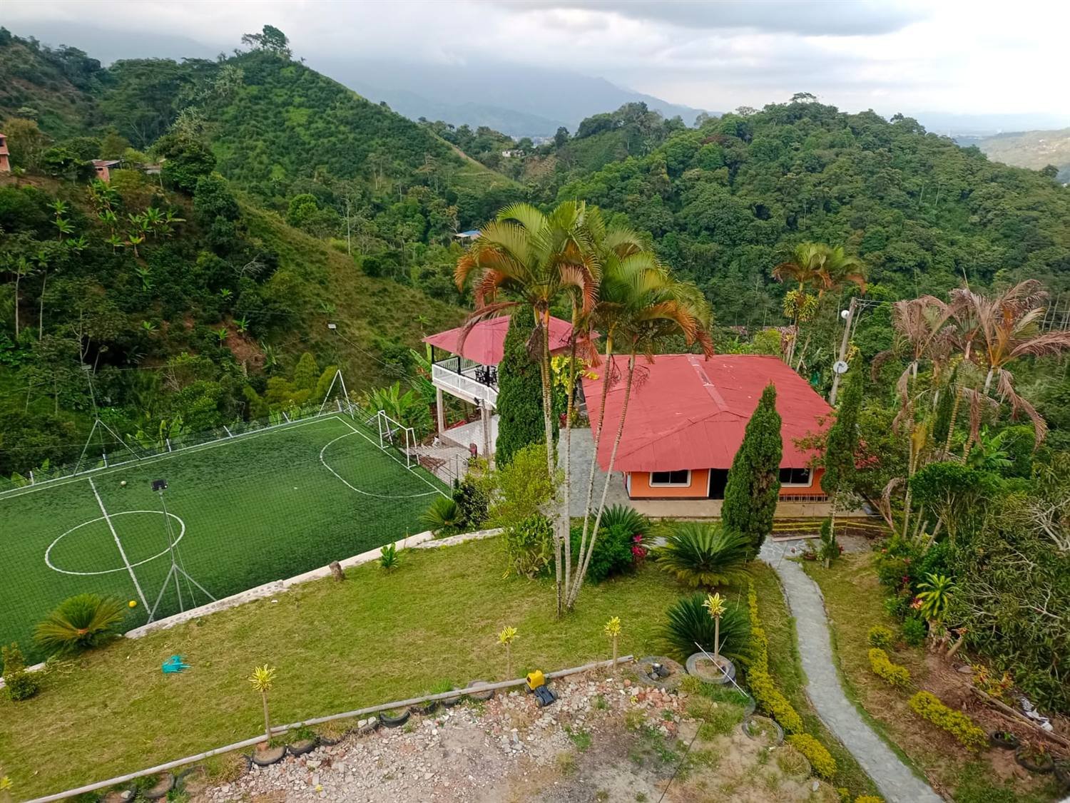 Vista aérea de la Finca Green Gold: la casa, la cancha y las montañas