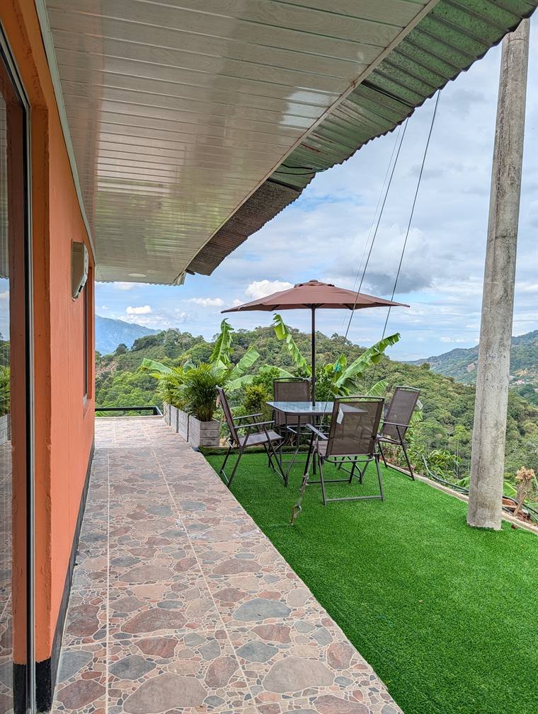 Terraza con sombrilla, mesa y sillas